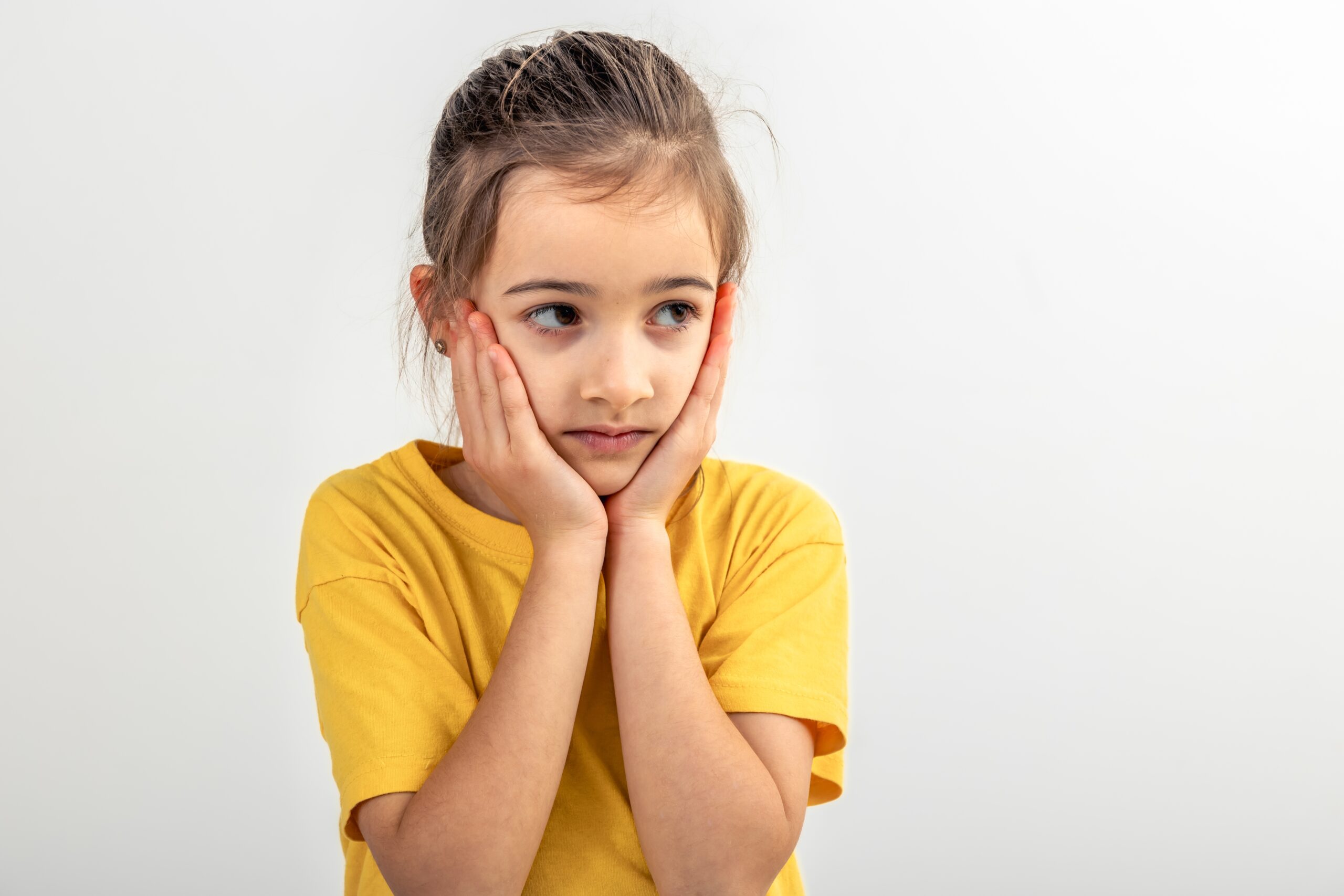 Little,Caucasian,Girl,Thoughtfully,Holds,Her,Head,On,A,White