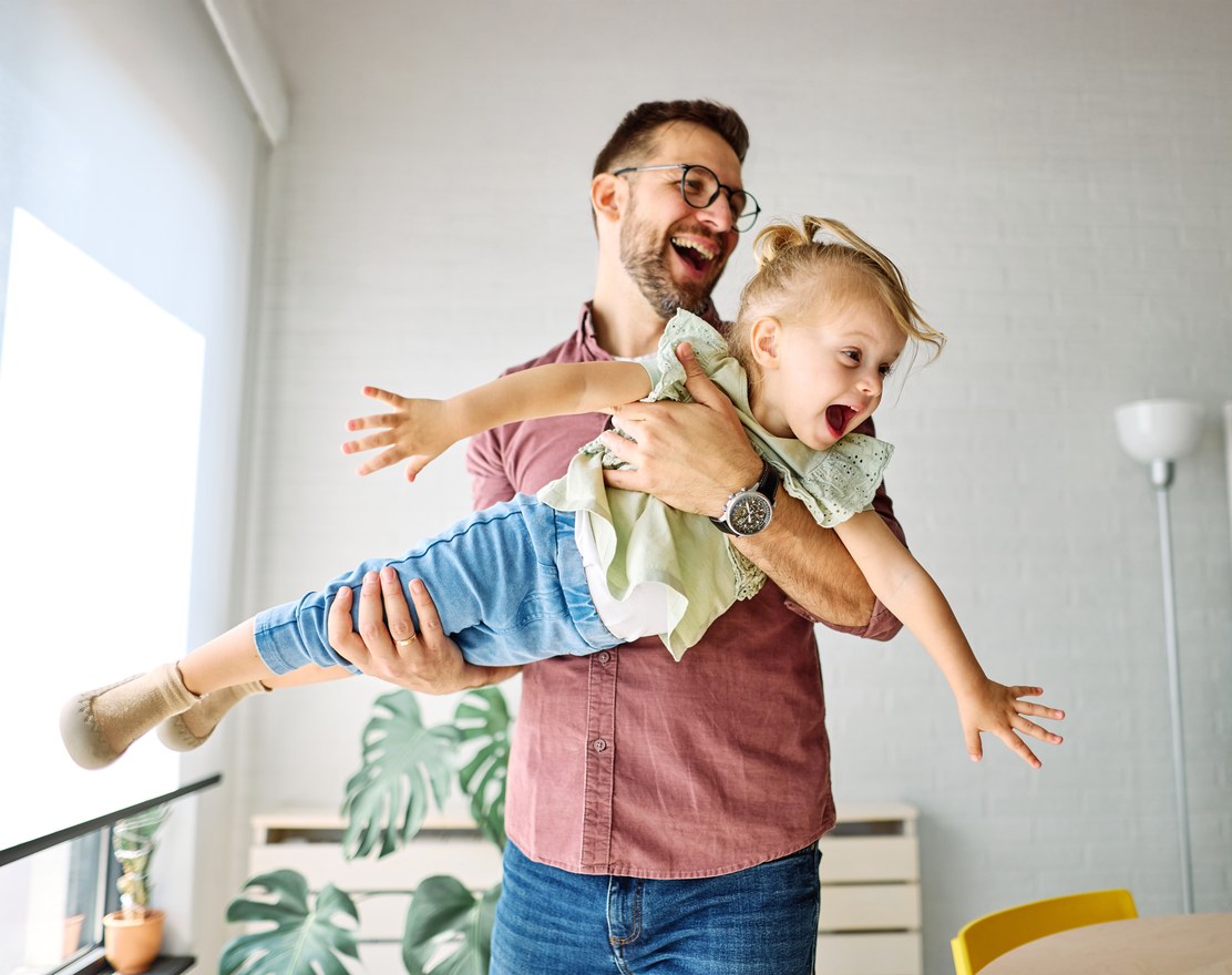 A father swinging his laughing child through the air