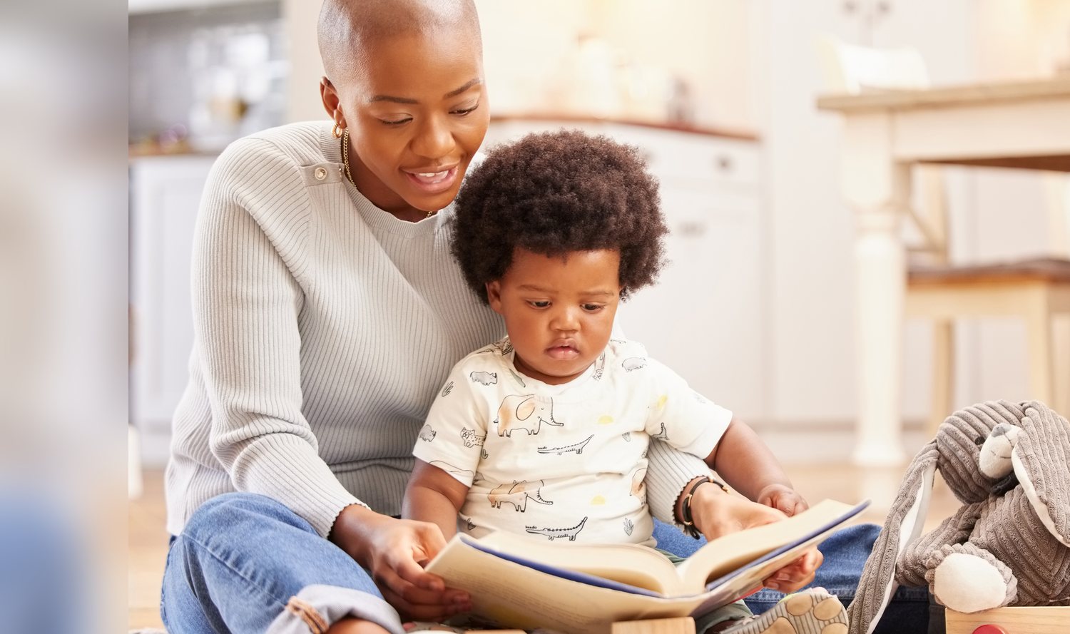 A parent reading a picture book with a toddler on their lap