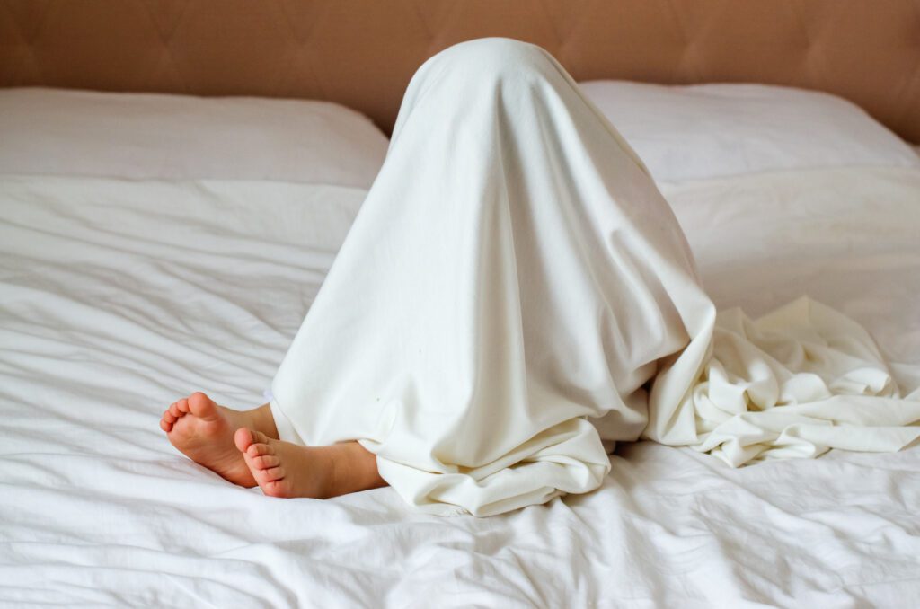 Little,Child,Hiding,Under,White,Blanket,In,Bedroom.,Play,Therapy